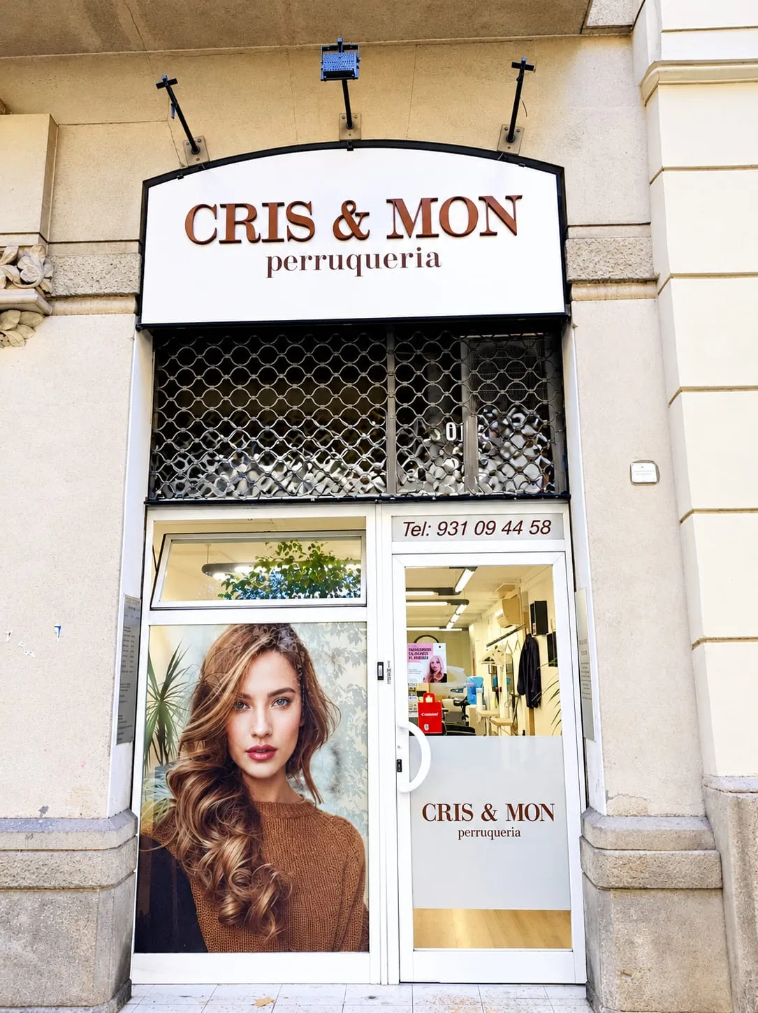 Fachada de la peluquería Cris & Mon con su rótulo y escaparate