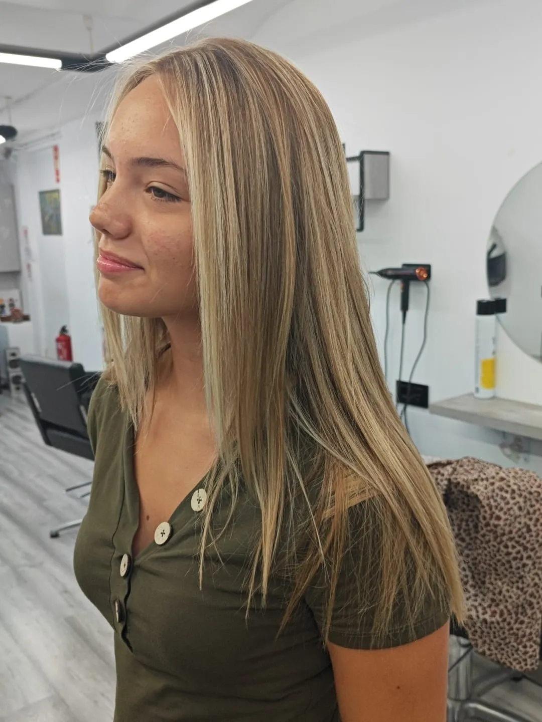 Melena lisa con reflejos rubios claros, vista de perfil en el salón